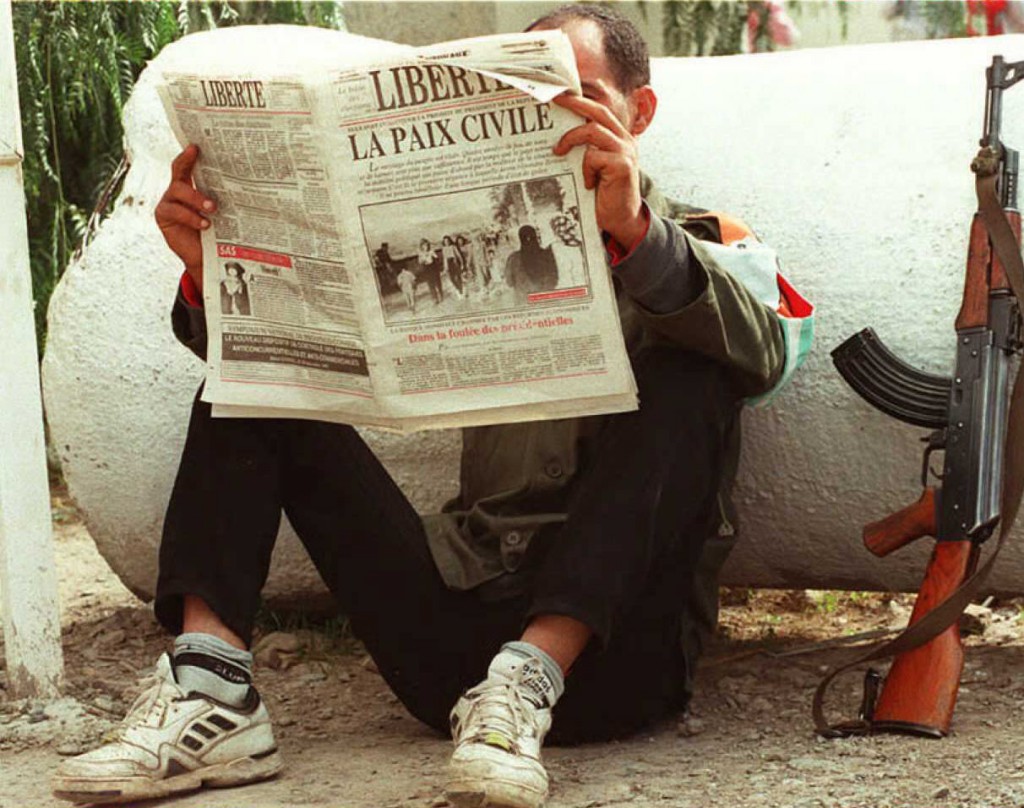 A militiaman in Sidi Moussa, Algeria, reads, 19 No