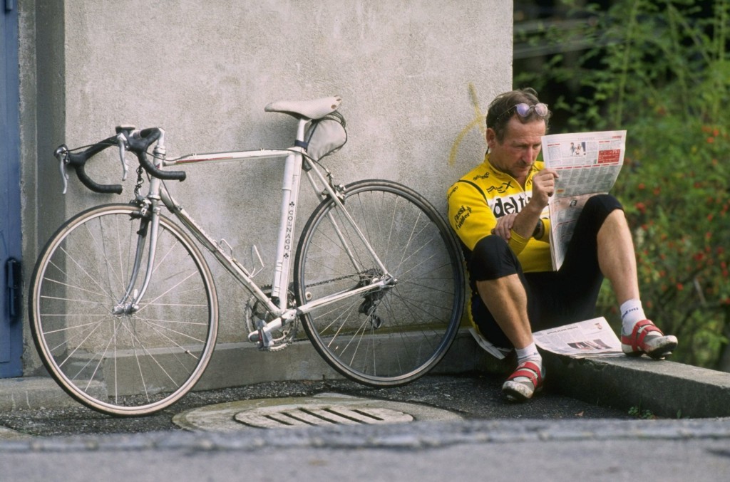 A keen cyclist reads the newspaper