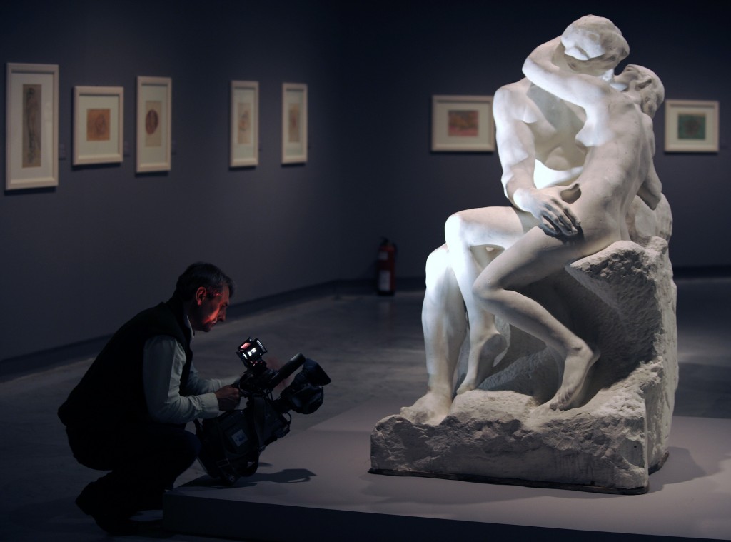 A cameraman films "The kiss" sculpture b