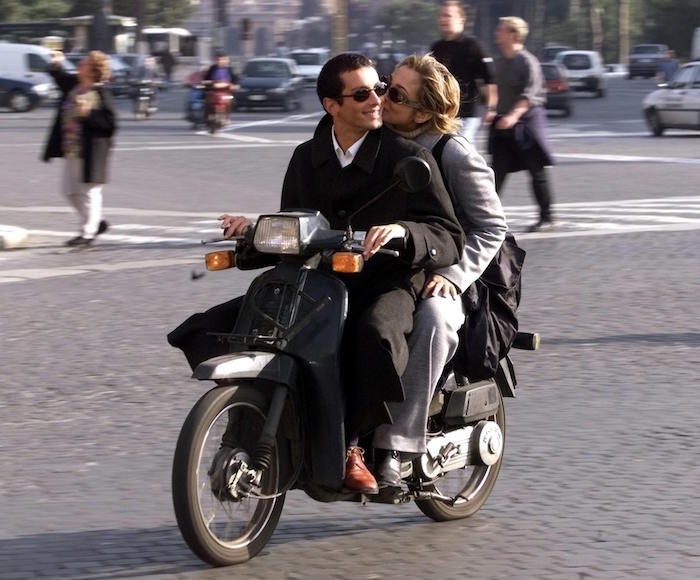 A Roman couples rides a moped without helmet in th