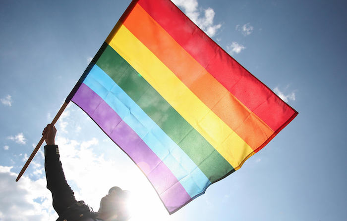 A Polish wave a rainbow flag as he takes